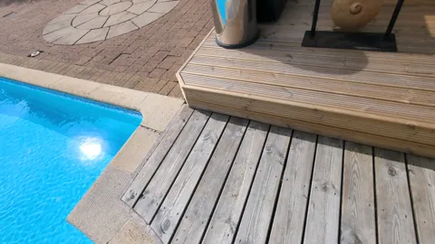 Corner of the new decking meeting the pool edging and block paving, Ayr
