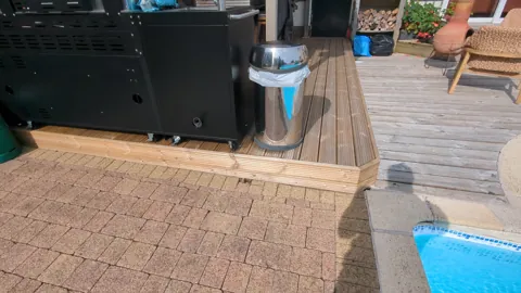 New decking boards cut round a post and up to the doorway, Ayr