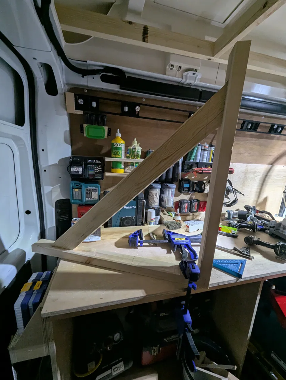 A new gallows bracket glued and clamped up on the bench in the van before being installed