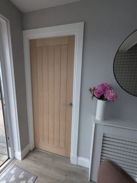 Oak veneered internal door hung in a Troon hallway with a chrome lever handle, matched to the existing doors and surround