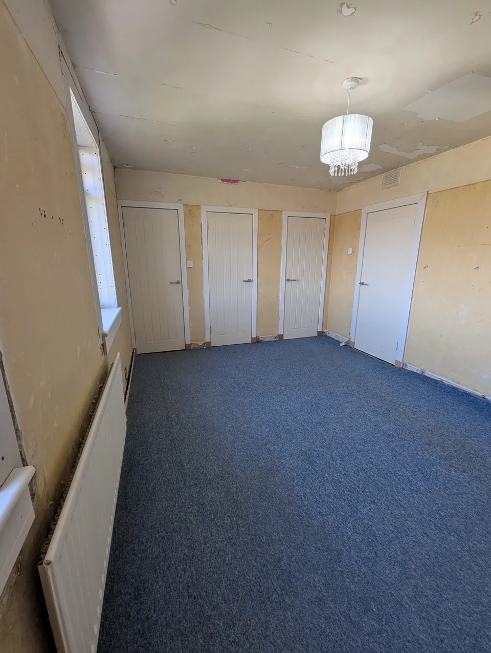 Cottage style internal doors hung in a stripped-back room in Dundonald during renovation