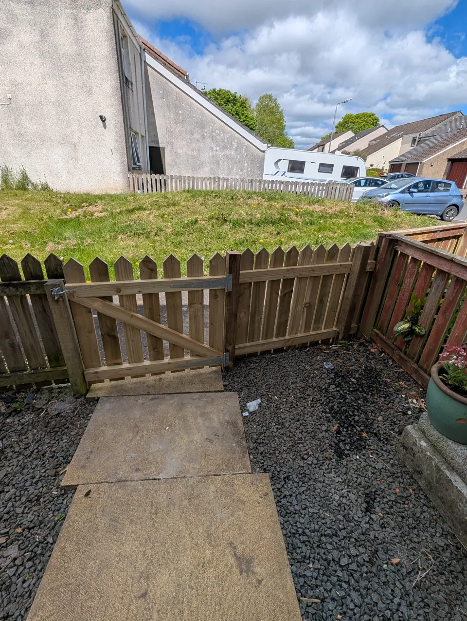 New picket fence and braced timber gate replacing the old front boundary at a home in Irvine