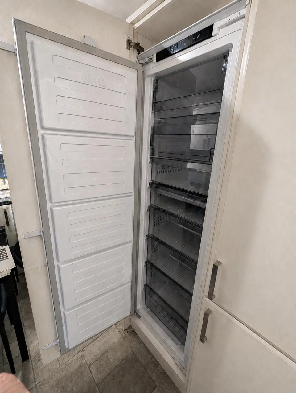 New integrated fridge freezer fitted into the existing kitchen housing in Irvine, door open showing the shelves