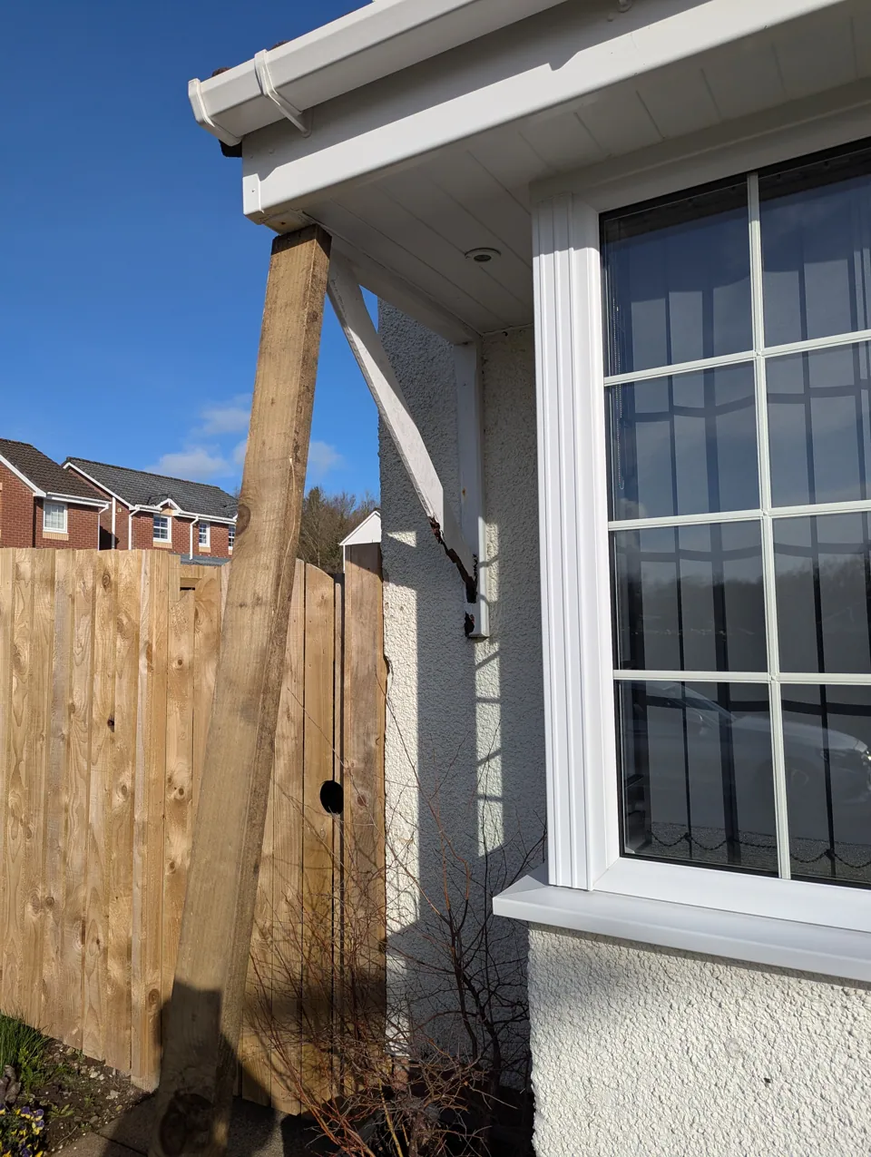The original gallows bracket rotted through at the wall, with a temporary timber prop holding the canopy
