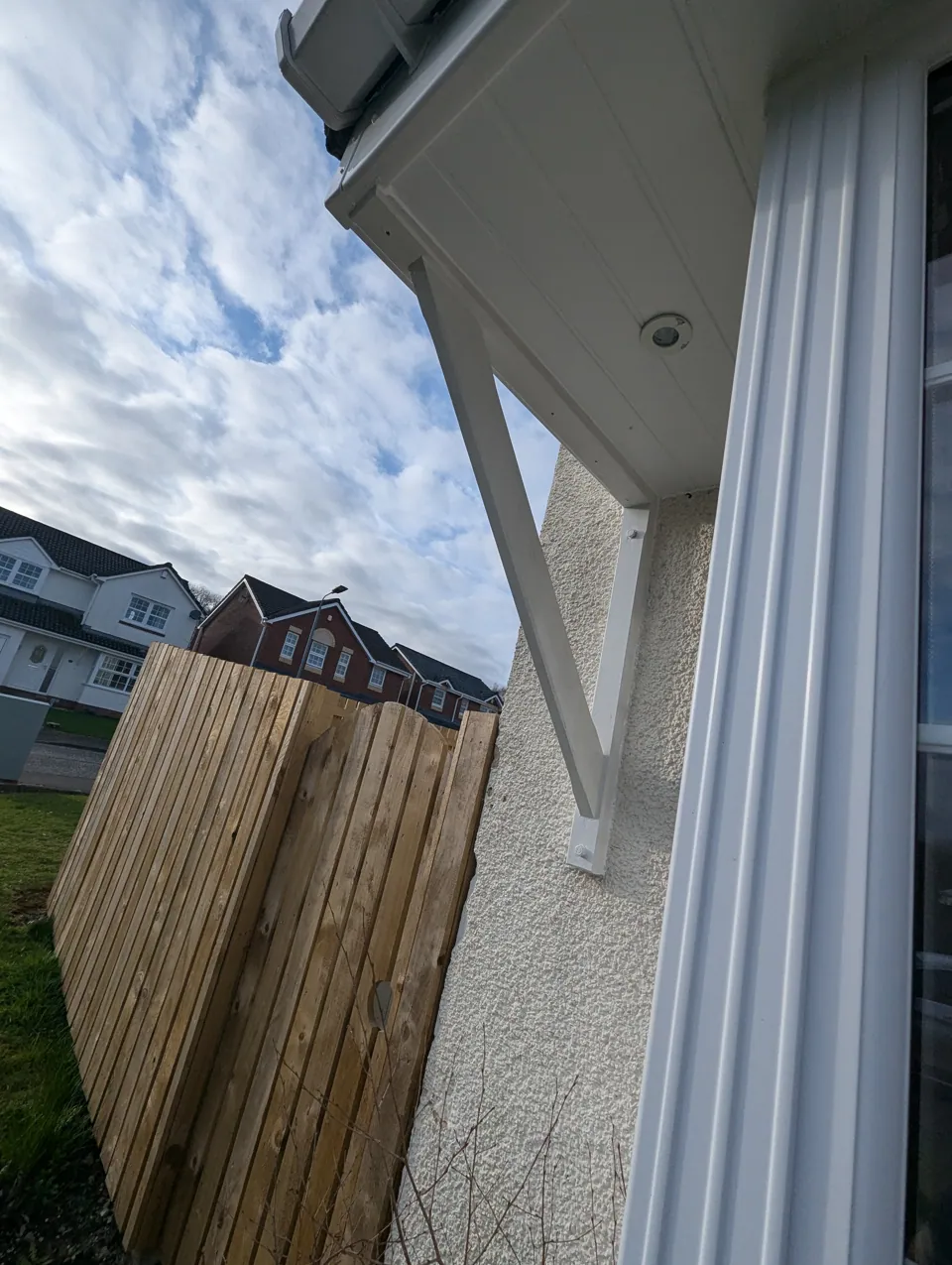 New gallows bracket installed and painted white, supporting a door canopy in Irvine