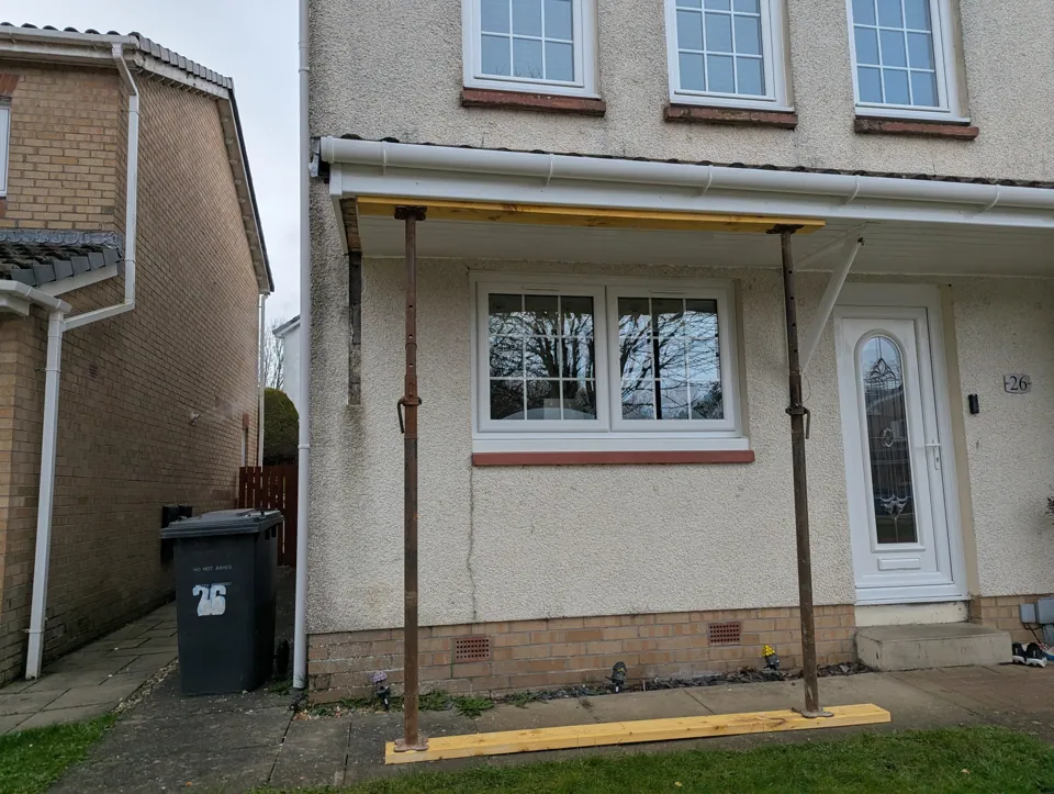 The full door canopy held on acrow props and a timber spreader beam while the failed gallows bracket was removed