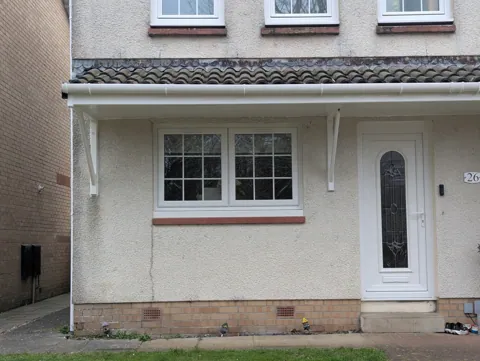 The door canopy back down on its gallows brackets and painted white to match the existing detailing, at a home in Irvine