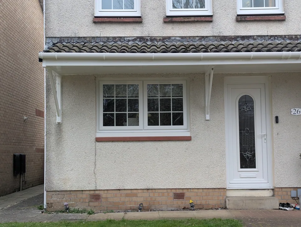 The door canopy back down on its gallows brackets and painted white to match the existing detailing, at a home in Irvine