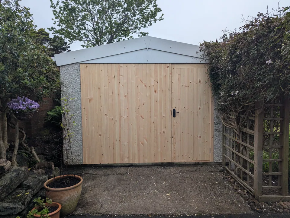 The completed garage front and door in bare timber before painting