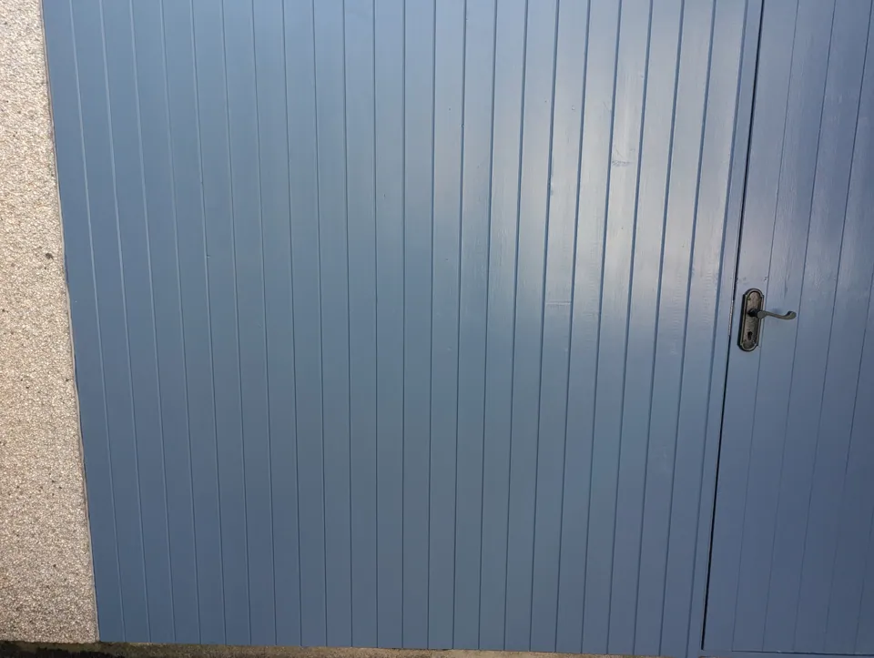 Close-up of the painted channel lining and the door's black lever handle and lock