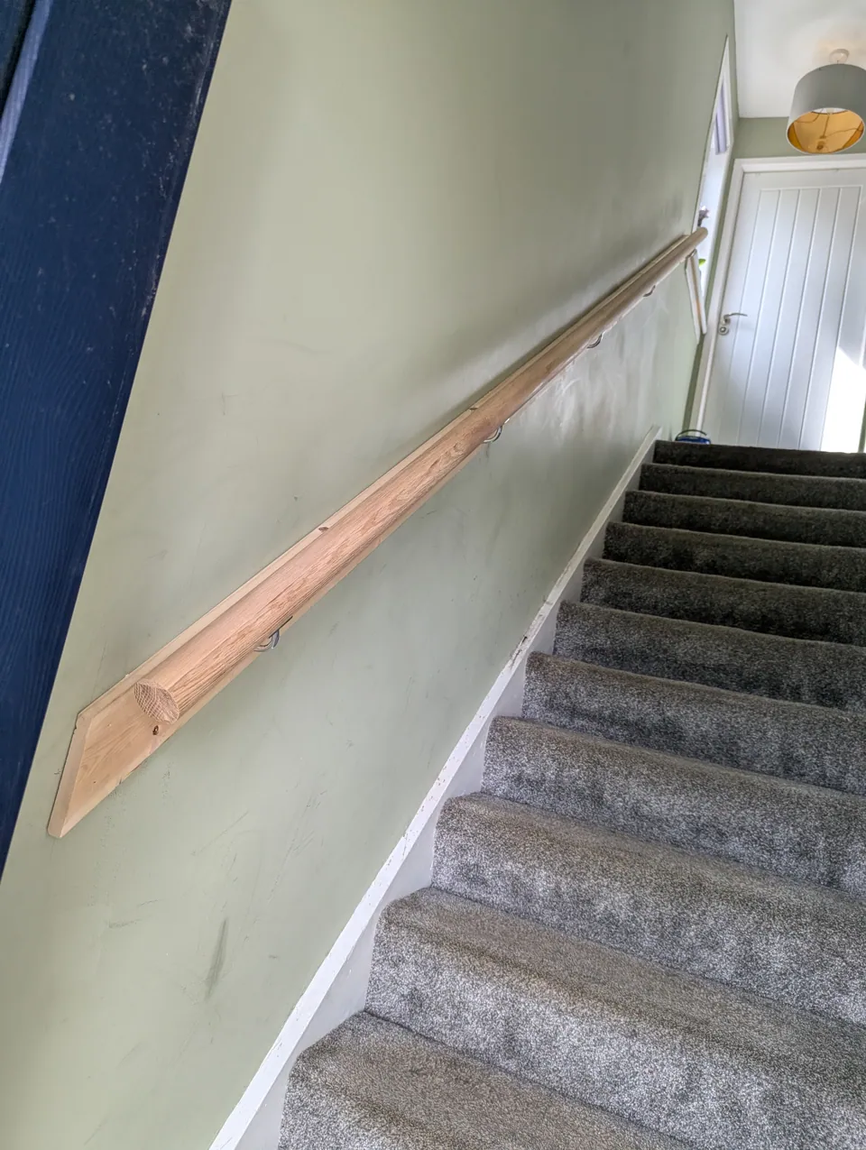 Oak mopstick handrail fitted the full length of a staircase in Saltcoats on chrome brackets, with the end cut and finished