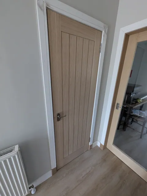 Oak cottage style door with chrome scroll lever handle and new white facings and skirting in Irvine