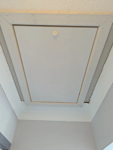 Finished loft hatch in a Troon home with a white architrave facing fitted around the opening