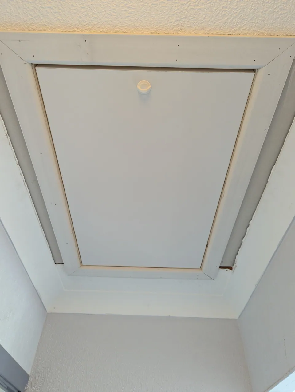 Finished loft hatch in a Troon home with a white architrave facing fitted around the opening