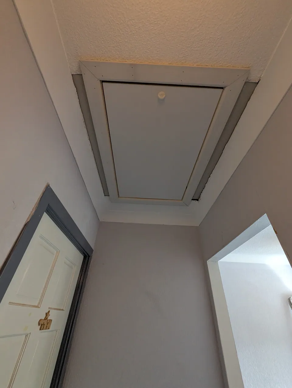 Loft hatch and architrave facing seen from the landing below