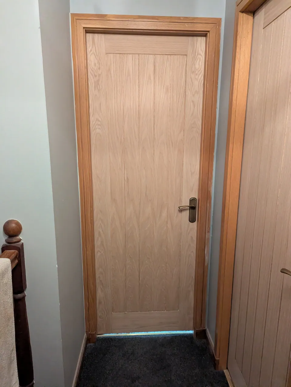 Oak veneered internal door fitted at the top of the stairs, seen from the landing