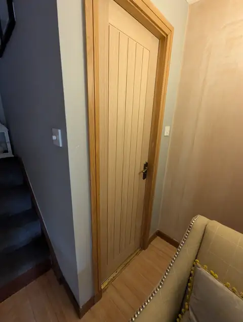 Oak veneer internal door fitted at the foot of the stairs in Lugton