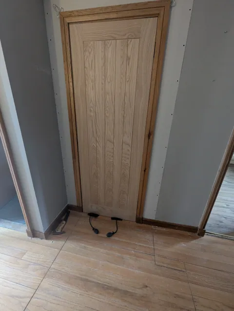 New stud wall boarded with plasterboard and an oak door frame fitted, Lugton