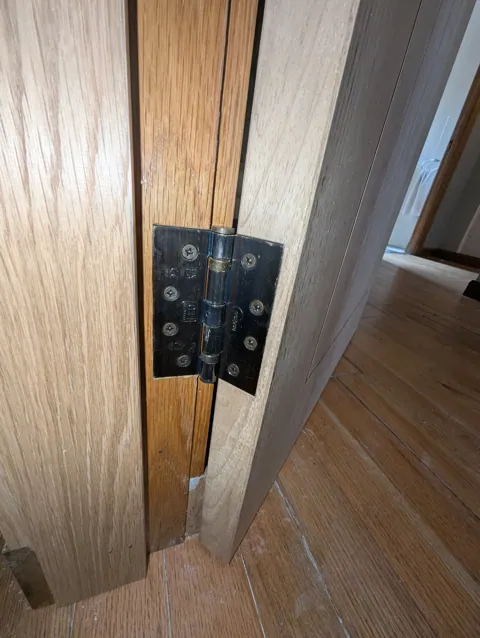 Antique brass lever handle on backplate fitted to an unfinished oak door in Lugton