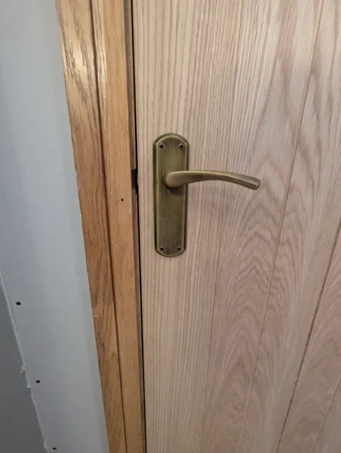 Eclipse tubular latch with antique brass forend fitted to the edge of an oak door in Lugton