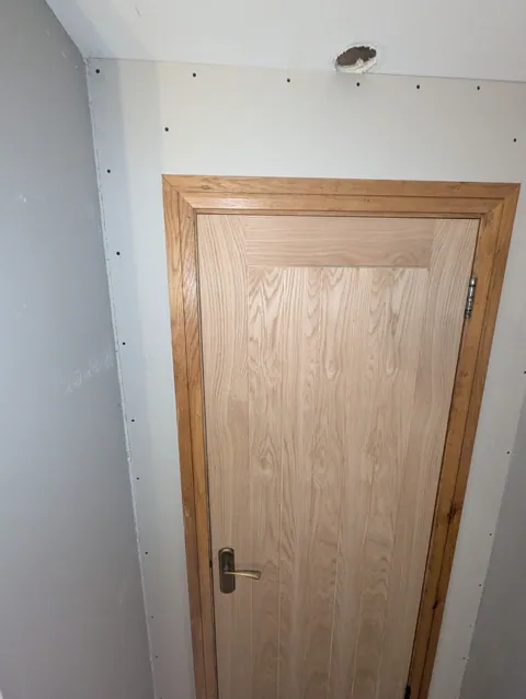 Top of the oak door and frame set into the new plasterboarded wall in Lugton