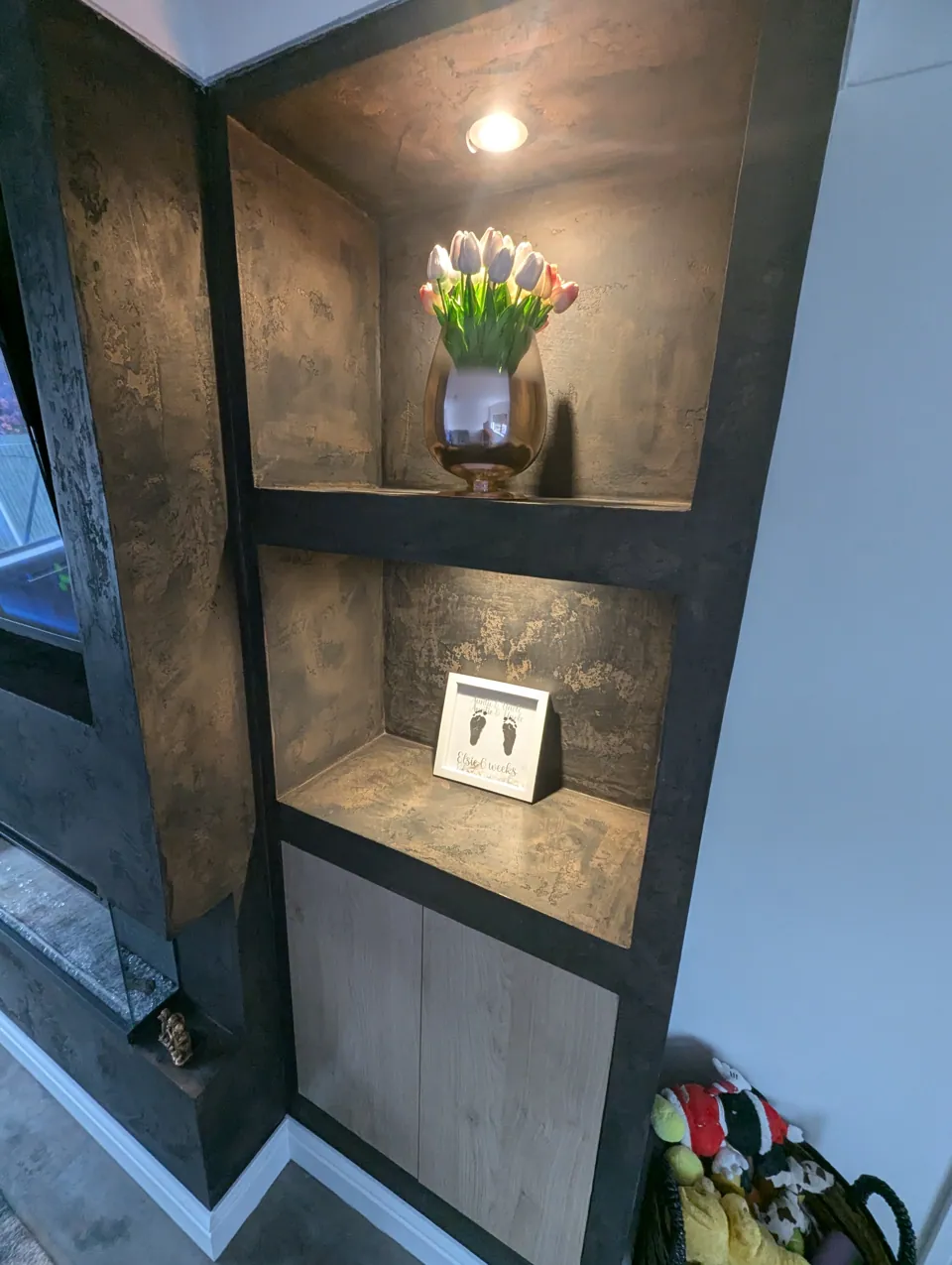 Close-up of a lit display alcove and cabinet, showing the depth and movement in the Venetian plaster finish