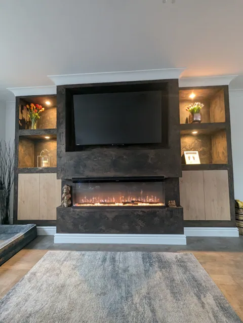 Media wall with the electric fire lit, showing the Venetian plaster finish and lit display alcoves