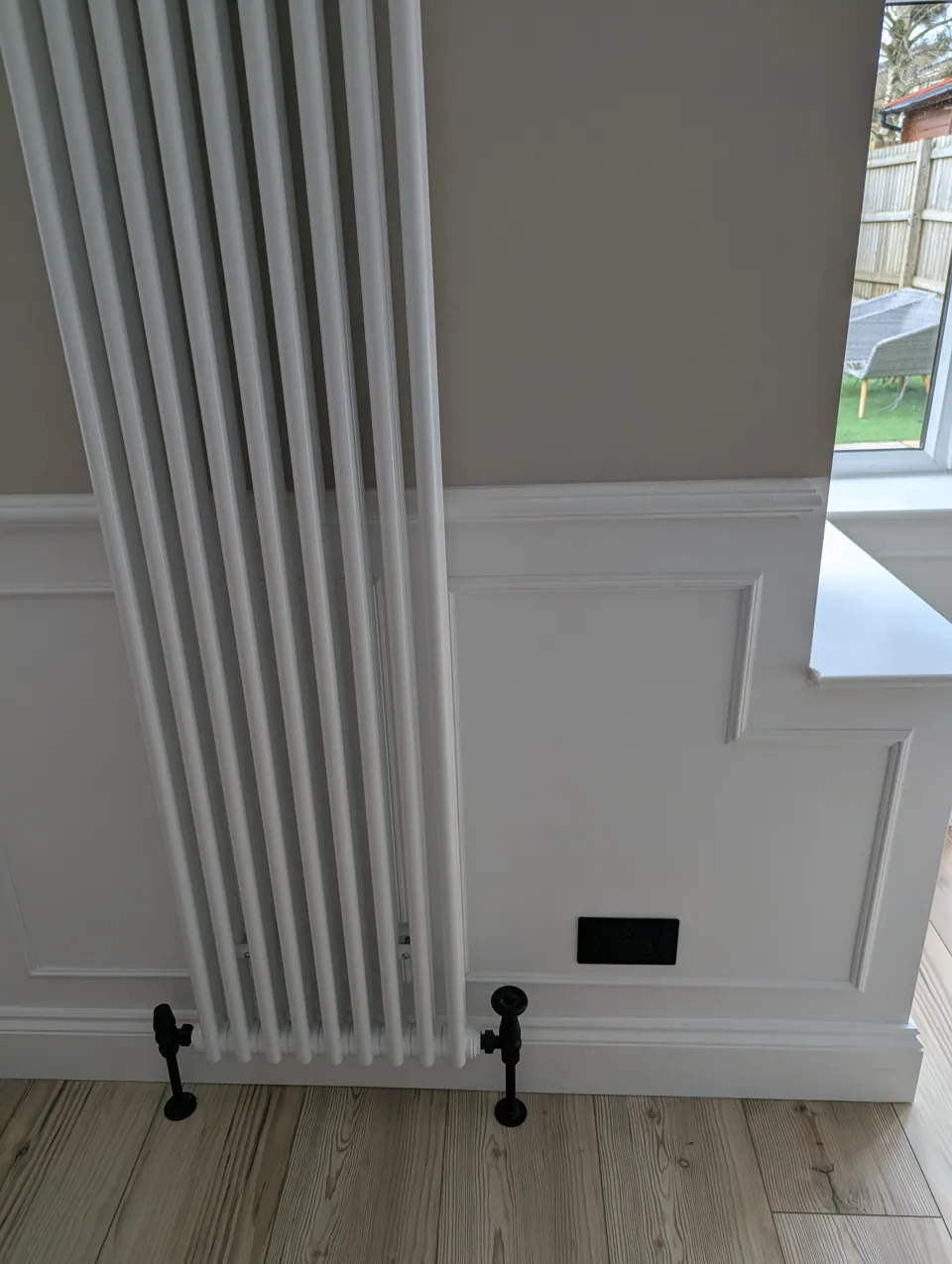Wall panelling with dado rail scribed around a column radiator in an Irvine home
