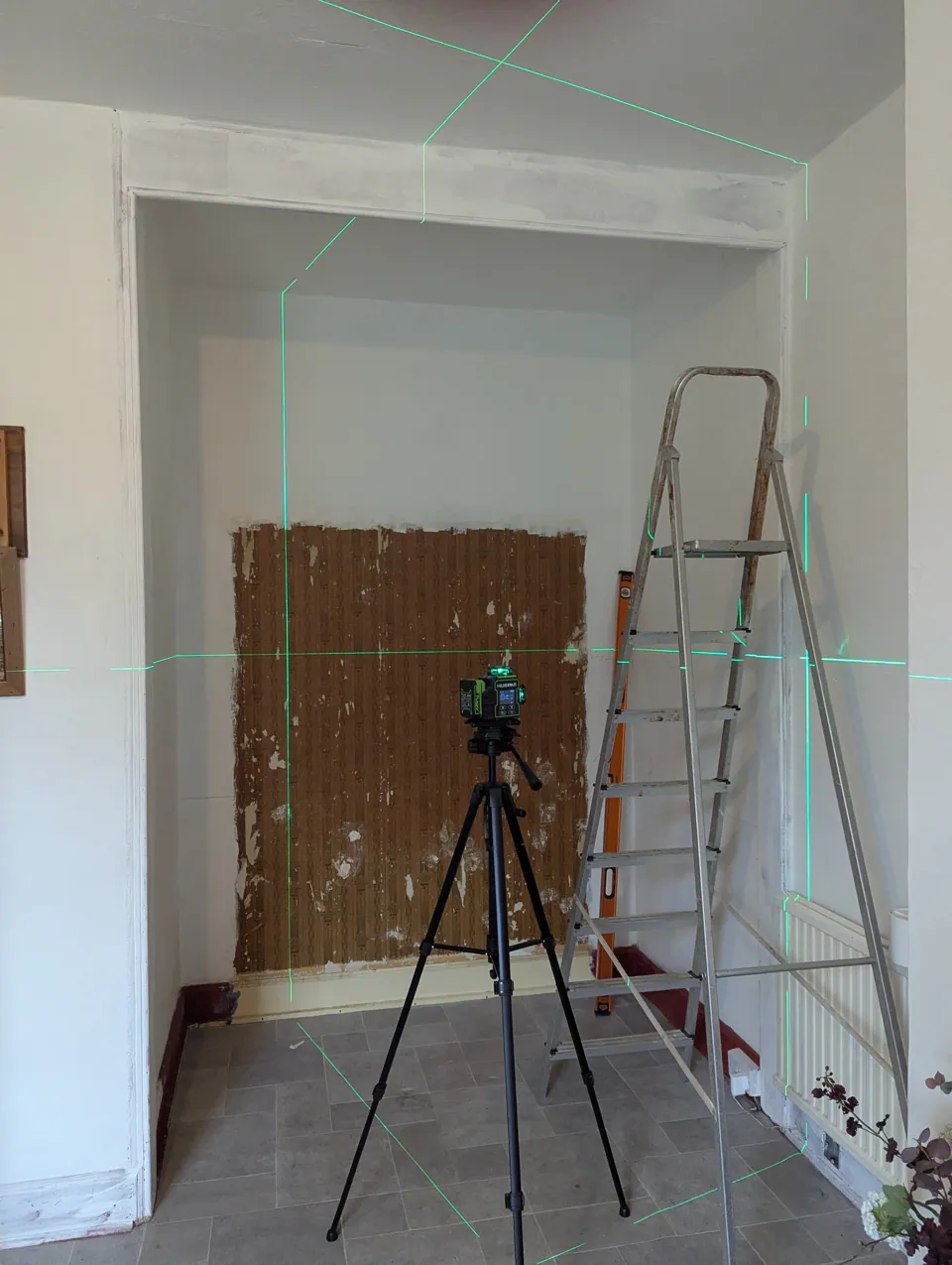 The kitchen alcove before work began, with laser lines set out across the opening