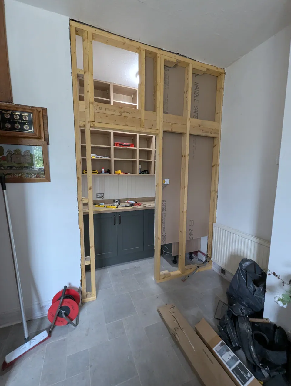 New stud wall framed up to form the pantry opening, with the fitted units visible through it