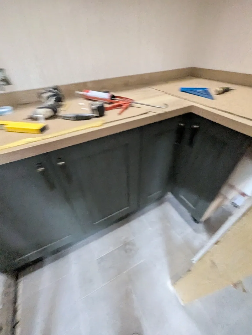 Base units and worktop being fitted along two walls inside the pantry