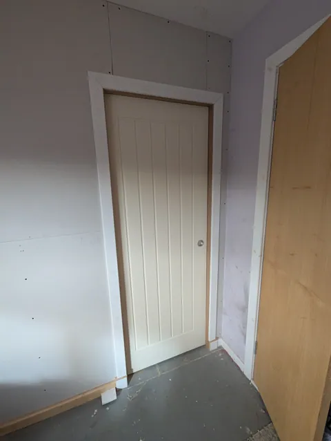White primed cottage style pocket door with flush pull fitted in a new plasterboarded stud wall in Irvine