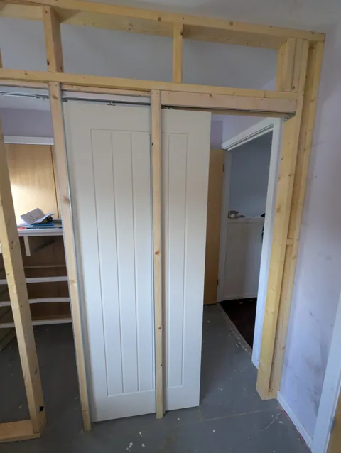 Pocket door sliding into the wall cavity during the build in Irvine