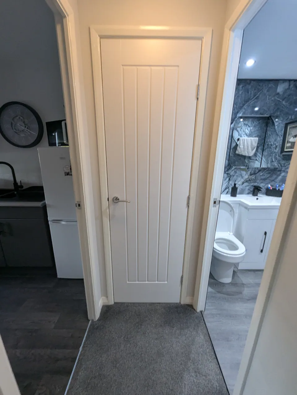 White cottage style door in a Prestwick hallway between the kitchen and bathroom