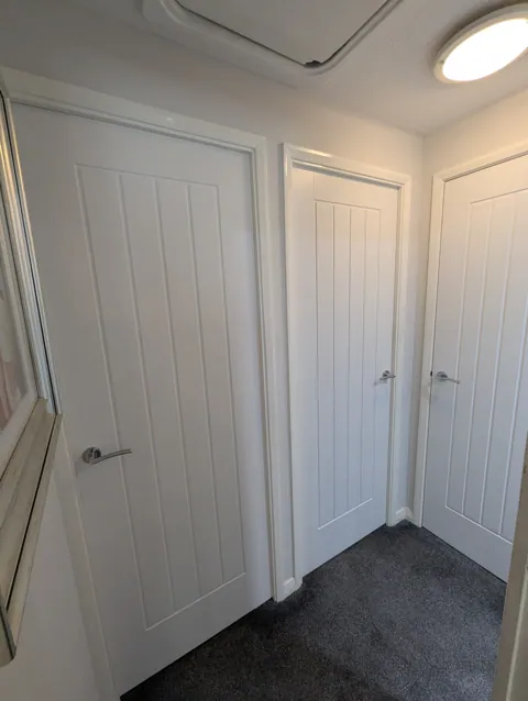 Three white cottage style doors fitted off a landing in a Prestwick home