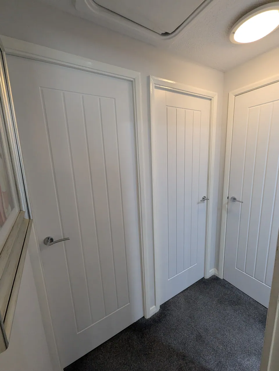 Three white cottage style doors fitted off a landing in a Prestwick home