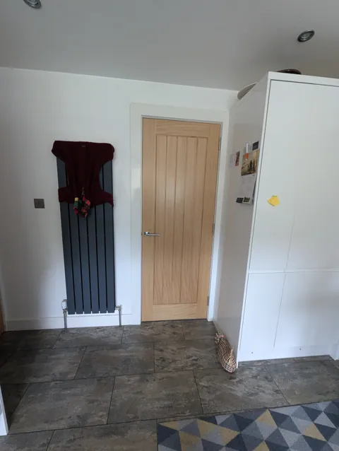 Prefinished oak cottage style door fitted beside a vertical radiator in a Prestwick home