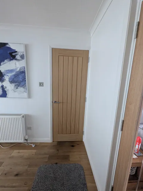 Deanta Ely oak door hung in a Prestwick home with white facings and skirting