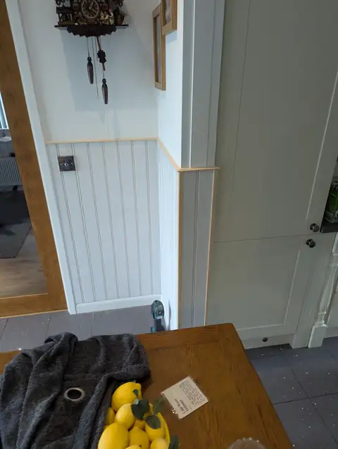 Tongue and groove panelling carried round the corner beside the kitchen, with capping rail and corner trim