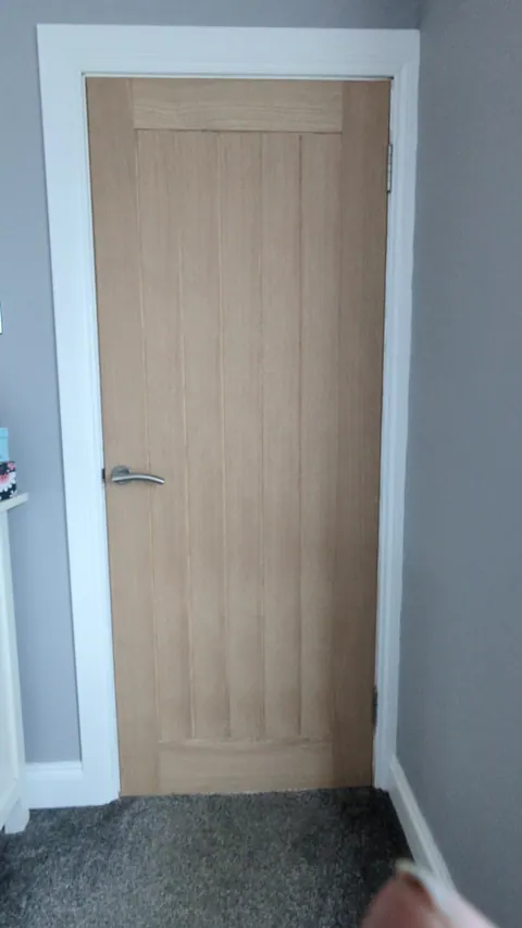 Oak veneered internal door hung in a Troon home with a chrome lever handle, matched to the existing doors